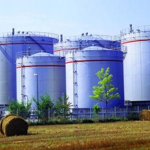 Factory With Smoke Stack Against Sky At Night.